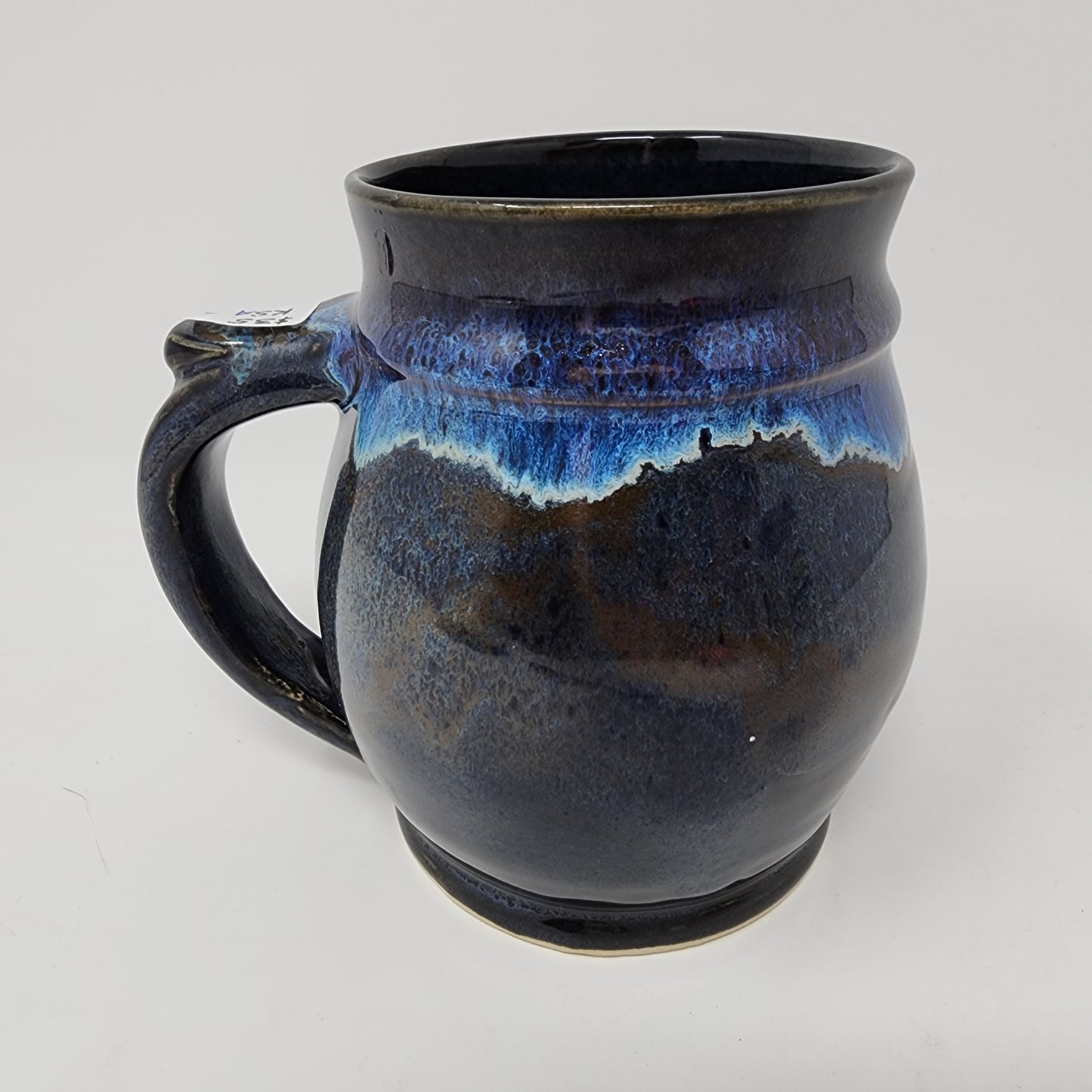 Shapely Black Glazed Mug with Blue Drip Accents