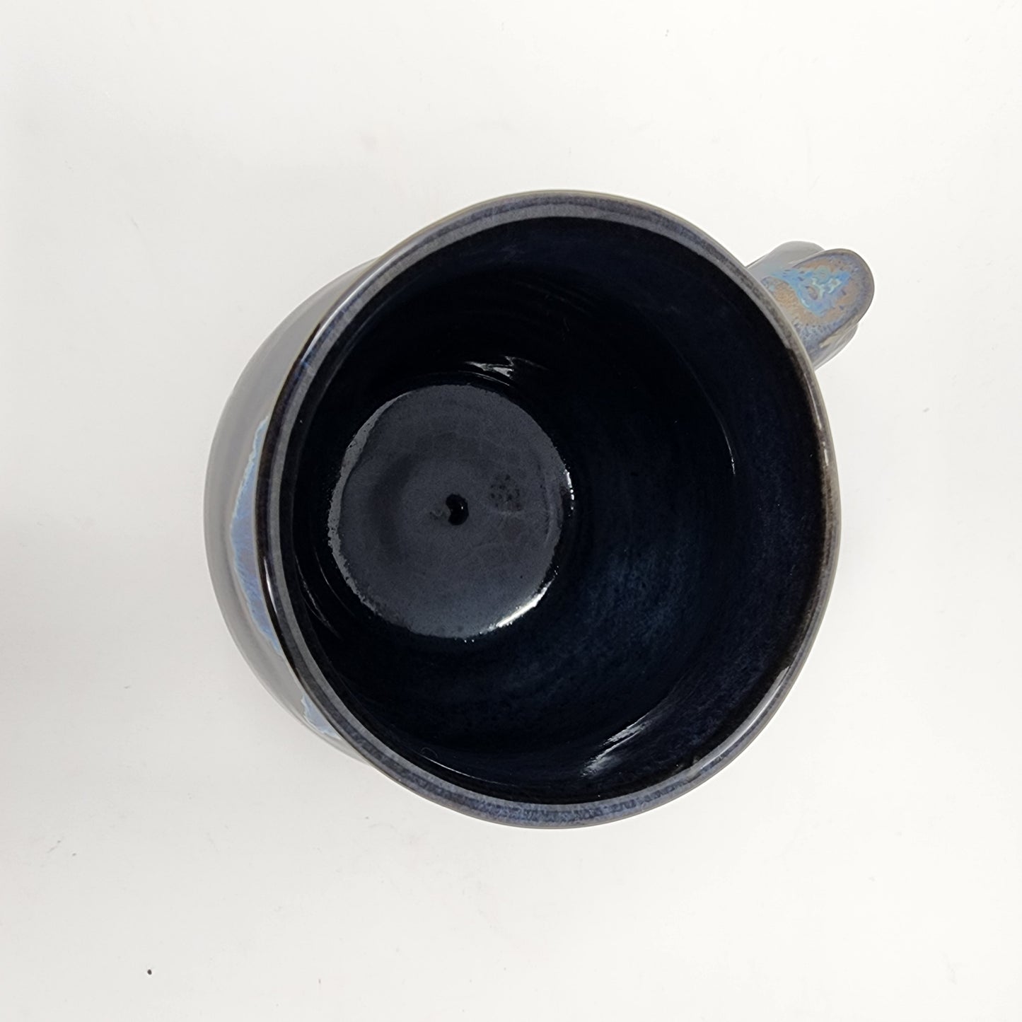 Shapely Black Glazed Mug with Blue Drip Accents